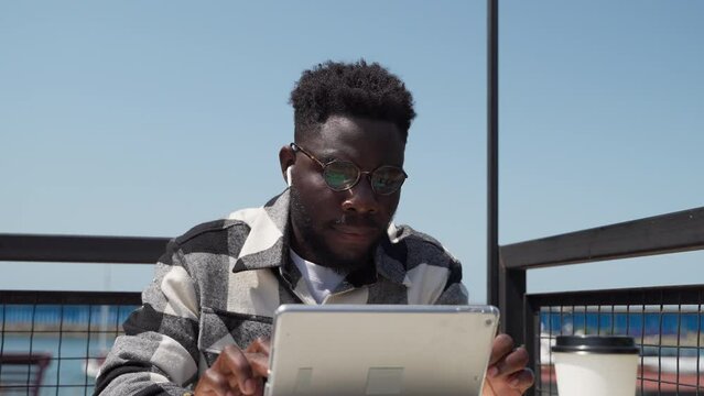 professional it specialist and programmer works remotely during travel, portrait black man in cafe