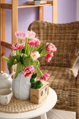 Vase with tulips, Easter bunny and teapot on end table in living room