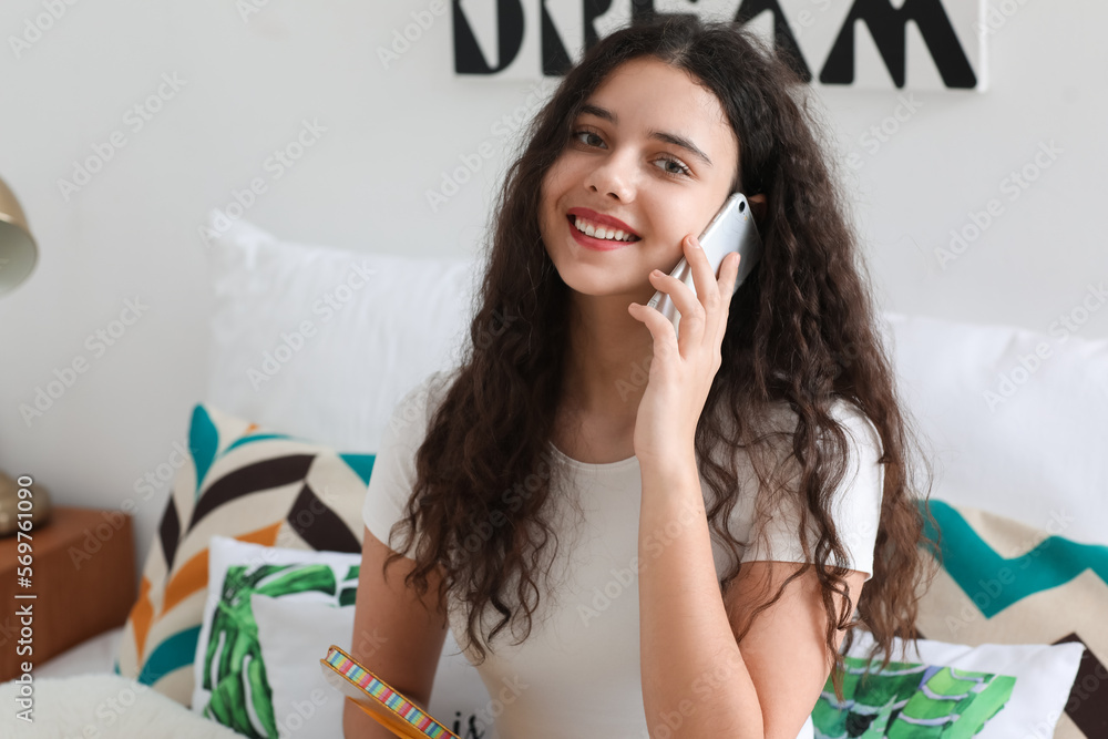 Canvas Prints teenage girl with notebook talking by mobile phone in bedroom