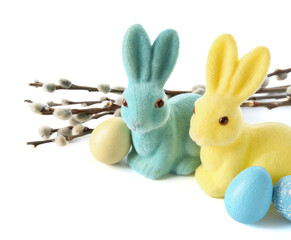 Easter bunnies, eggs and willow branches on white background