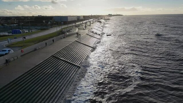 Slow motion waves on sea defences in winter at Cleveleys with drone rise up