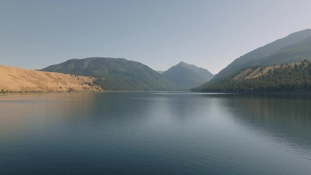 Aerial moving over hazy mountain lake in western USA