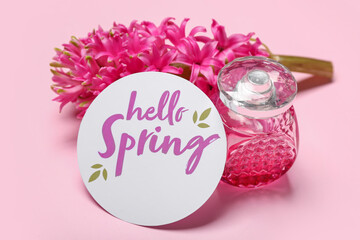 Card with text HELLO SPRING, bottle of perfume and hyacinth flower on pink background