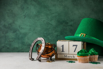 Cupcakes for St. Patrick's Day, cube calendar, leprechaun hat, horseshoe and pot of coins on white...