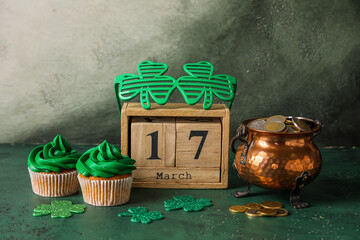 Tasty cupcakes for St. Patrick's Day, cube calendar with date MARCH 17, pot of coins and party...