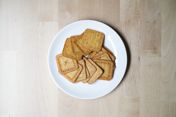 Homemade thin crispy crackers on white plate, Selective Focus.