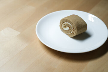 Coffee roll cake on white plate, Selective Focus.