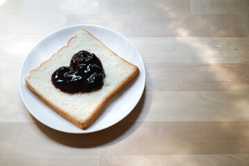 Bread with jam in shape of heart on white plate, Homemade bread for breakfast in the morning.
