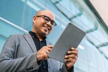 Senior manager business man in suit with tablet at the buildings downtown. Confident man using digital tablet looking towards their goals for success. Executive business man