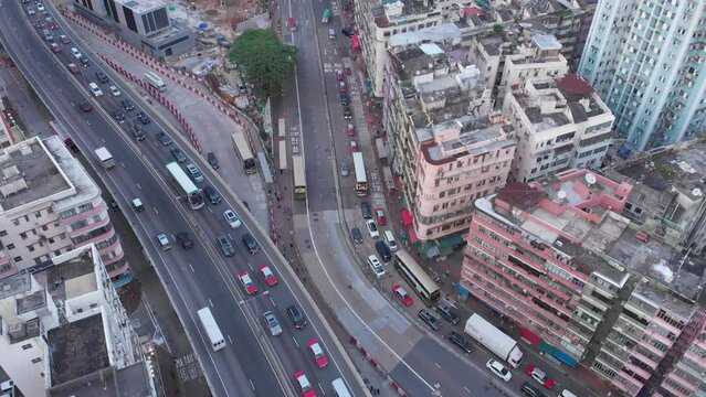 Kowloon traffic in Hong Kong. Aerial view of cars and trucks below. Drone above busy downtown streets in Asia, China. Popular travel destination.