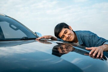 Young handsome asian man getting the new car. He hugged his car and was very happy touching detail...