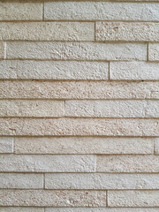 Cream colors stone wall textured creating rough surface with brick pattern