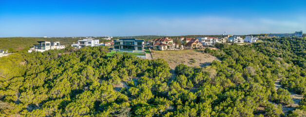 Austin, Texas- Mountain top with mansions near the forest with trees. Rich neighborhood surrounded by green trees in a panoramic view.
