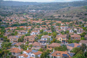 Fototapeta na wymiar Large houses in a wealthy neighborhood near the hiking trail at San Clemente, California. View from a hiking trail of a neighborhood near the mountain slopes.