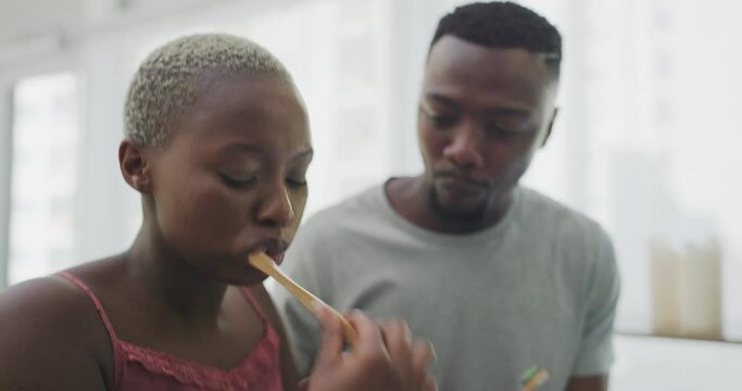 Brushing teeth, love and black couple with toothbrush in bathroom for morning routine, dental care and wellness. Smile, dating and man and woman with toothpaste for oral hygiene, health and cleaning