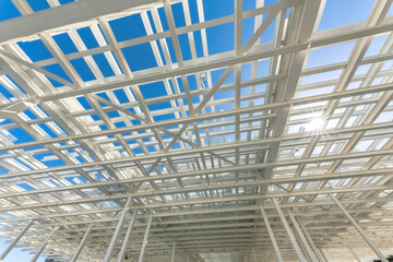 Views of a multiple layered white metal roof grids from below at Waterloo Park in Austin, Texas. Low angle view of roof grids against the clear blue skies and sunlight.