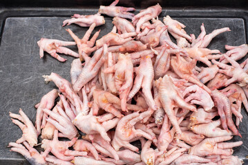 Raw chicken feets in a market stall close-up view in Chengdu, Sichuan province, China - 569784871
