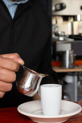 man's hand serving espresso coffee cut