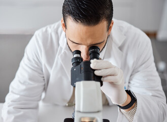 Science, microscope and a doctor man at work in a laboratory for innovation or research. Medical, analytics and biotechnology with a male scientist working in a lab for breakthrough