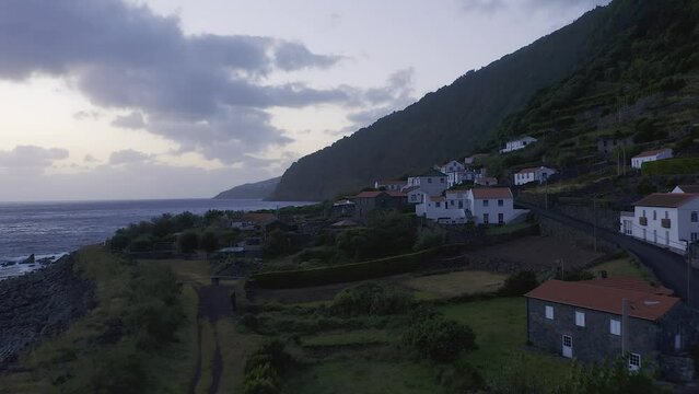 rural coastal village in lush green cliffs on blue hour, Faj&atilde; dos Vimes, S&atilde;o Jorge island, the Azores, Portugal
