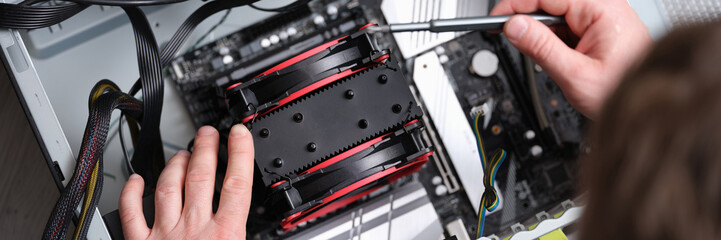 Repairman works with screwdriver and repairs computer equipment