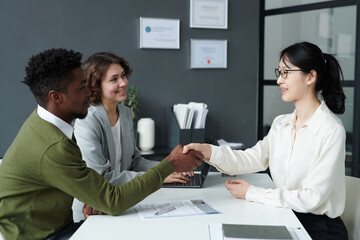 African American employer shaking hands with candidate during their meeting in modern office