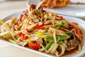 Delicious Som Tam -Thai green papaya salad with green beans,
 tomatoes, peanuts. Thai street food . Healthy vegan food