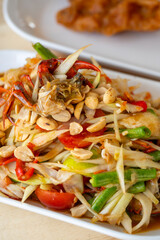 Delicious Som Tam -Thai green papaya salad with green beans,
 tomatoes, peanuts. Thai street food . Healthy vegan food