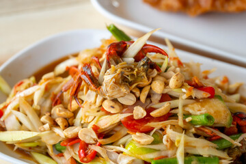 Delicious Som Tam -Thai green papaya salad with green beans,
 tomatoes, peanuts. Thai street food . Healthy vegan food