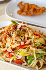 Delicious Som Tam -Thai green papaya salad with green beans,
 tomatoes, peanuts. Thai street food . Healthy vegan food