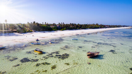 Zanzibar looks like paradise in this drone shot, with a beautiful beach and wooden boats left behind at low tide.