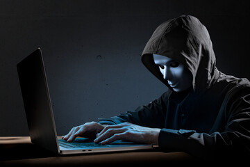 仮面を被ったハッカー。サイバーテロ、特殊詐欺のイメージ