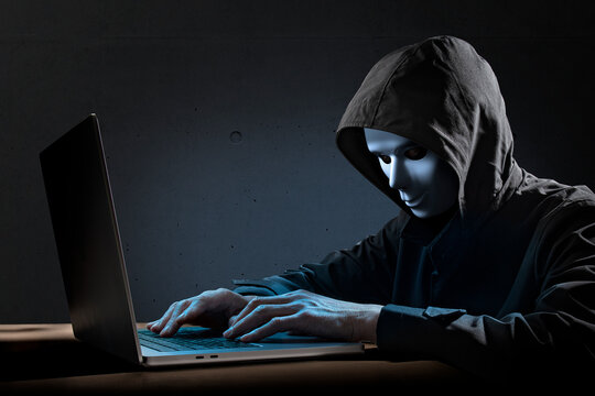 仮面を被ったハッカー。サイバーテロ、特殊詐欺のイメージ