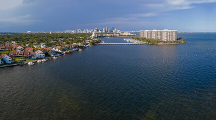 Miami Florida beautiful city skyline with waterfront buildings and houses. Scenic aerial view of ocean and buildings with blue sky background.
