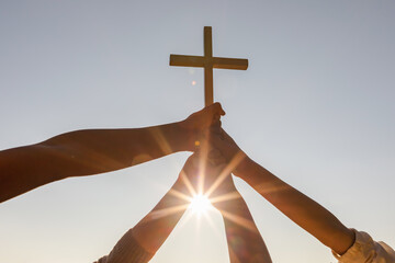 Christian, Christianity, Religion copy space background. Group hands praying and holding christian cross for worshipping God at sunset background.silhouette