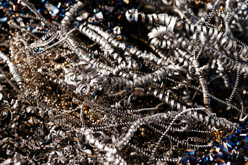 Pile of curvy steel chips on floor in production workshop