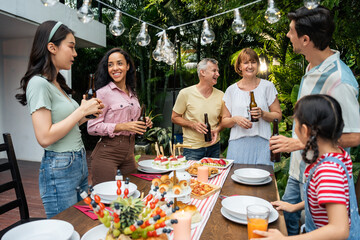 Multi-ethnic big family having fun, enjoy party outdoors in the garden. 