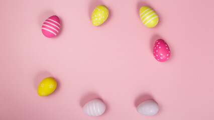 Happy easter banner. Colored Easter eggs on a pastel pink background. Copy space