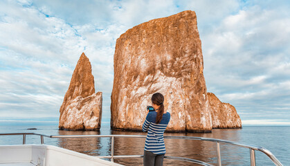 Galapagos Islands Cruise ship tourist taking pictures of Kicker Rock nature landscape. Iconic...