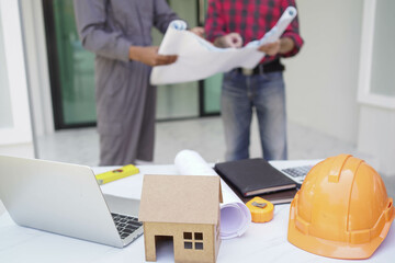 Smiling young architect or engineering builder in hard hat with tablet over group of builders at construction site, architect watching some a construction, business, building, industry, people concept
