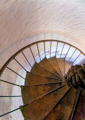High angle perspective view of spiral stairs in Cape Florida Lighthouse in Miami, Florida. Vertical shot of metal spiral stairs inside the lighthouse at Bill Baggs Cape Florida State Park.