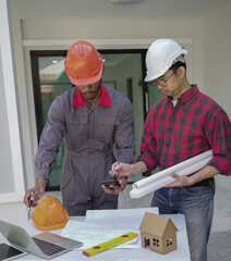 Smiling young architect or engineering builder in hard hat with tablet over group of builders at construction site, architect watching some a construction, business, building, industry, people concept