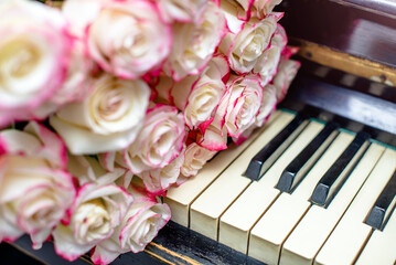 A bouquet of white roses lies on the piano keys