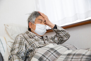 風邪、体調不良、病気で寝込むシニアの日本人男性