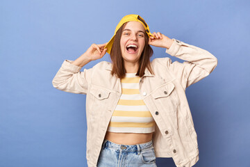 Image of joyful cheerful Caucasian teenager girl wearing baseball cap and jacket posing isolated...