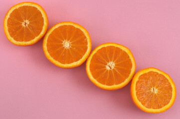 Oranges coupées sur fond rose