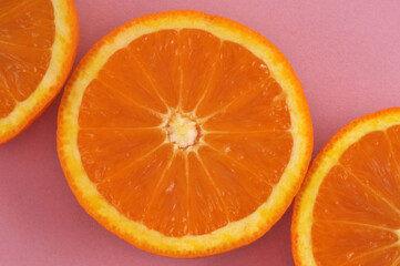 Oranges coupées sur fond rose