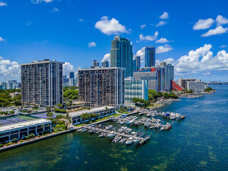Fototapeta na wymiar Harbor on Miami South Channel with skyscrapers against blue sky background- Miami Beach, Florida. Coastline modern high-rise buildings in an aerial view.