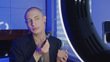 bald influencer young man streaming makeup tutorial video, medium closeup LGBT concept. High quality photo - obrazy, fototapety, plakaty