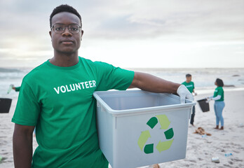 Cleaning, recycling and portrait of black man on beach for sustainability, environment or eco friendly. Climate change, earth day or nature with volunteer and plastic for charity or community service